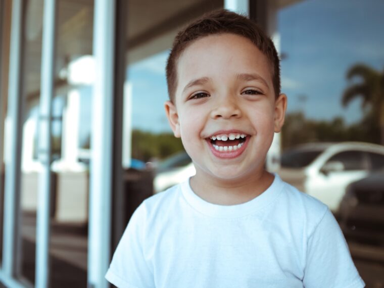 smiling boy wearing white crew-neck t-shirt during daytime